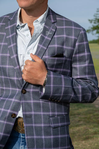 Person wearing a purple checkered blazer with a blurred outdoor background