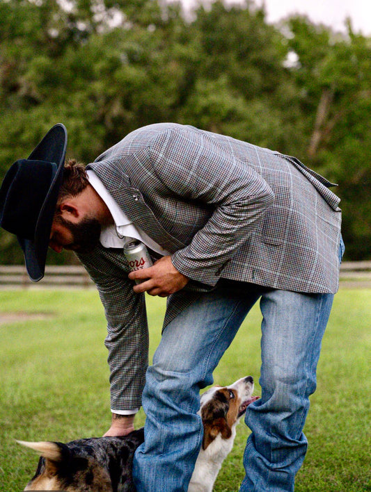 Model wearing turquoise grey brown plaid cowboy sport coat with jeans and boots
